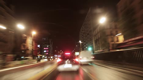 Timelapse-captures-the-frenetic-pace-of-a-night-time-street-scene,-dominated-by-streaks-of-light-from-passing-cars-under-the-glow-of-street-lamps