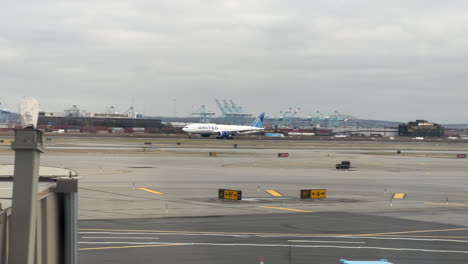United-Airplane-737-800-Taking-Off-In-Background-On-Runway-At-Newark-Airport