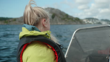 Ein-Hübsches-Mädchen,-Das-Auf-Einem-Kleinen-Motorboot-Auf-Einem-Wunderschönen-Fjord-In-Südnorwegen-Sitzt,-Hobbyfischer,-Lächelndes-Mädchen-Mit-Einer-Schwimmweste