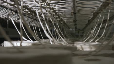 Underneath-Large-Textile-Loom,-Machine,-Clothing-Factory,-Punjab-Pakistan