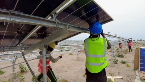 Arbeiter-Installieren-Bifaziale-Photovoltaikmodule-über-Stahlrahmenkonstruktionen-Beim-Solarparkprojekt-In-Jambur,-Gambia,-Westafrika