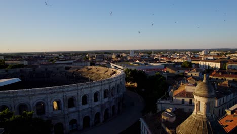 Aufschlussreiche-Luftaufnahme,-Die-Die-Arena-Von-Nîmes-Und-Das-Musée-De-La-Romanité-Bei-Sonnenuntergang-Zeigt