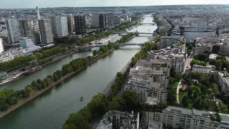 Flying-over-Ile-aux-Cygnes-or-Isle-of-Swans-at-Beaugrenelle-district-and-bridges-in-Paris,-France
