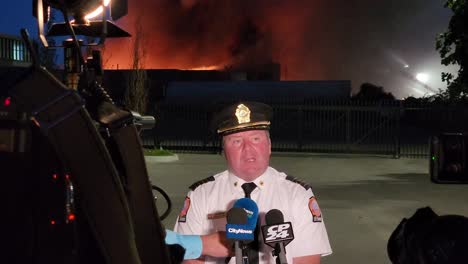 Toronto-Fire-Deputy-Chief-Giving-Update-On-Massive-Industrial-Fire-Accident-At-Night-In-Etobicoke,-Toronto,-Canada