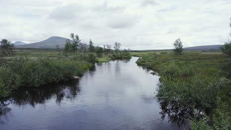 Peaceful-river-flows-through-remote-Norway-plateau-on-breezy-day