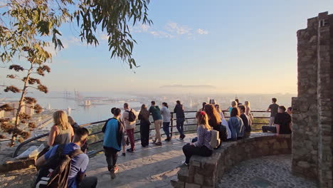 Grupo-De-Turistas-Tomando-Fotos-Del-Atardecer-Sobre-La-Ciudad-De-Málaga-Desde-El-Mirador.