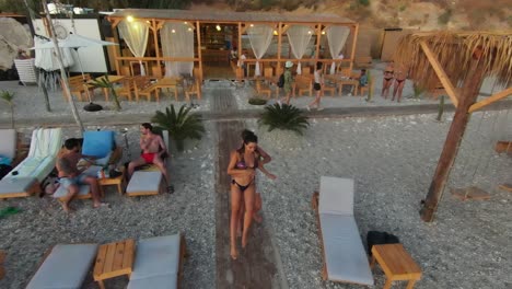 Drone-shot-of-sexy-couple-dancing-bachata-on-sandy-beach-of-hotel-Resort-in-front-of-seascape-at-sunset,-Lebanon---backwards-flight