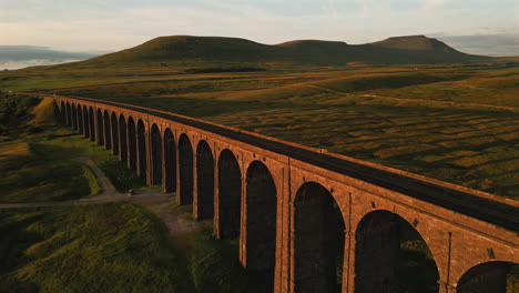 Establishing-Drone-Shot-of-Ribblehead-Viaduct-with-Ingleborough-in-Background-at-Golden-Hour