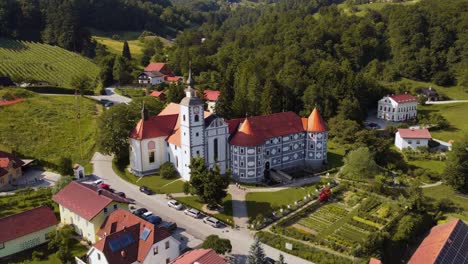 Luftaufnahme-Der-Burg-Olimje-Mit-Parkenden-Autos-Umgeben-Von-Einer-Wunderschönen-Grünen-Landschaft-In-Slowenien