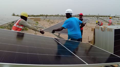 African-Engineers-and-Technicians-Shape-the-Future-by-Installing-Bifacial-Solar-Photovoltaic-Panels-Power-Plant-in-Gambia,-Slow-Motion