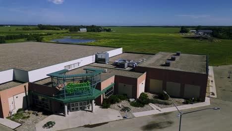 Eine-Von-Außen-Bewegte-Drohnenaufnahme-Des-Freizeitzentrums-Und-Der-Eisbahn-Der-Shamrock-Community-In-Der-Kleinstadtgemeinde-Killarney,-Manitoba,-Kanada