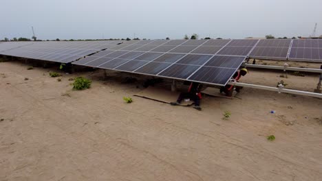 Ingenieros-Y-Técnicos-Trabajando-Instalando-Paneles-Solares-En-El-Monte-De-La-Granja-Solar-En-Gambia,-África-Occidental