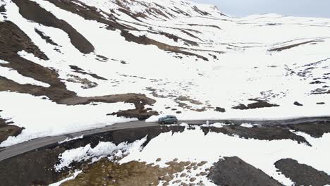 Luftaufnahme-Einer-Verschneiten-Landschaft-Mit-Einem-Jeep,-Der-Auf-Dem-Komic-Bezirk-Von-Himachal-Pradesh,-Dem-Höchsten-Dorf-Der-Welt,-In-Indien-Fährt
