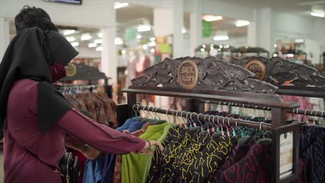 Family-looks-at-clothes-on-a-hanging-rack-at-the-Batik-Trusmi-Cirebon-market