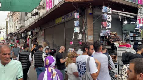 Panning-view-of-people-exploring-and-shopping-in-a-crowded-open-air-bazaar-in-Istanbul,-Turkey