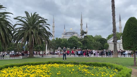 Fesselnde-Landschaftsansicht-Der-Ikonischen-Struktur-Der-Blauen-Moschee-Und-Touristen,-Die-Den-Sultan-Ahmet-Park,-Istanbul,-Türkei,-Besuchen