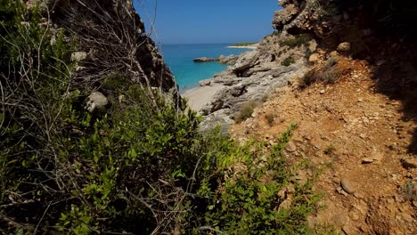 Beautiful-unspoiled-seaside-with-paradise-beach-discovered-through-wild-bush-and-cliffs,-cinematic-summer-landscape-in-Mediterranean