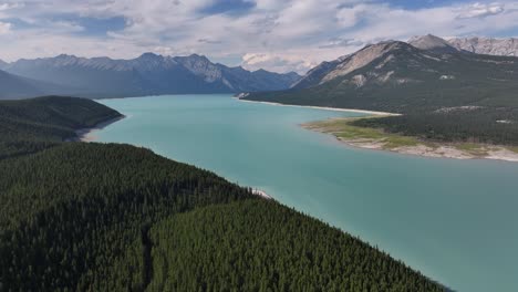 The-turquoise-waters-of-Abraham-Lake-as-seen-from-a-drone-as-it-flies-across-the-forest-of-the-Rocky-Mountains-of-Alberta,-Canada