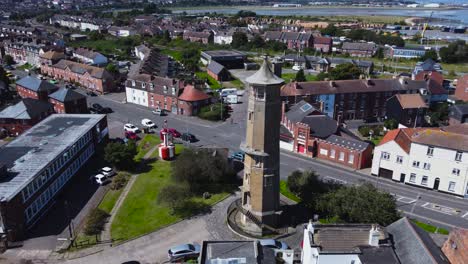Orbit-Drone-Shot-of-Harwich-Lighthouse-and-Traffic,-Buildings-all-around