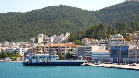 Ships-moored-in-the-port-of-Igoumenitsa,-Greece,-with-city-buildings-and-mountains-in-the-background