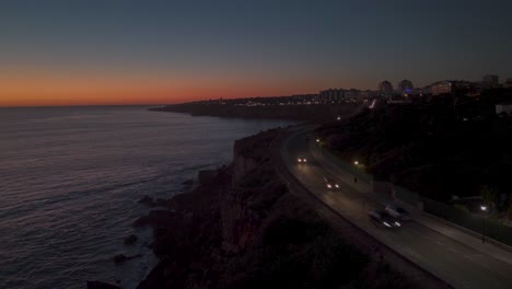 Luftaufnahme-Der-Felsigen-Küste-Am-Meer-In-Der-Stadt-Cascais-Bei-Sonnenuntergang,-Portugal