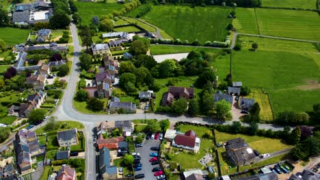 Aerial-time-lapse-of-cars-driving-through-Stoke-Bruerne,-sunny-day-high-angle