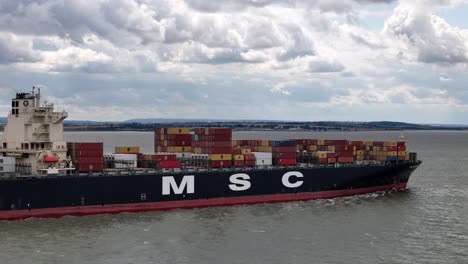 Close-up-MSC-Madeleine-container-ship-sailing-up-river-Thames-Estuary-Aerial-drone