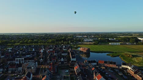 Aerial-of-a-newly-built-town-with-a-distant-hot-air-balloon-in-a-blue-sky