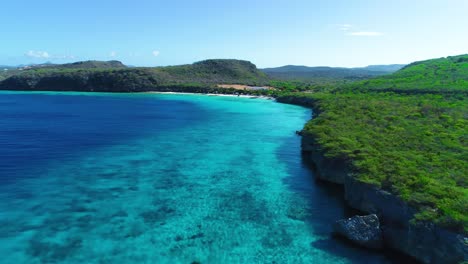 Panoramic-aerial-view-of-curacao-green-coastline-with-deep-blue-turquoise-ocean-waters