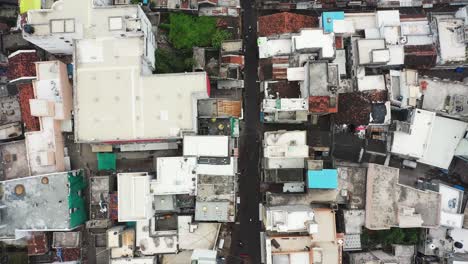 Aerial-top-down-view-of-old-Rajkot,-showing-old-residential-thatched-houses-on-both-sides-of-the-street-market-and-the-surrounding-complex