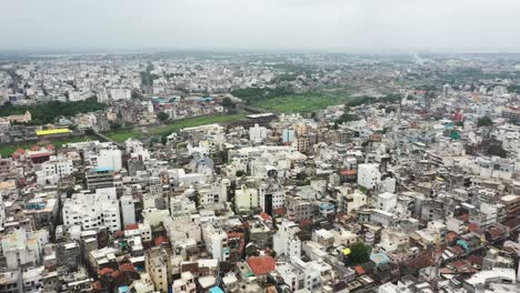 Luftaufnahme-Der-Alten-Stadt-Rajkot-Mit-Hochhaus-Wohnkomplexen,-Umgeben-Von-Alten-Gebäuden-Und-Einem-Fluss,-Der-Durch-Die-Stadt-Fließt