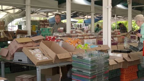People-looking-at-groceries-on-UK-town-market-stalls-during-cost-of-living-crisis-inflation