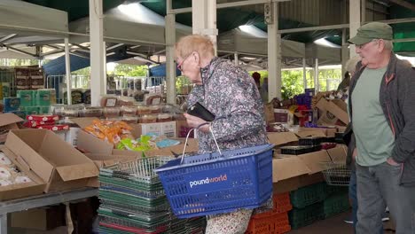 Ältere-Menschen-Stöbern-Während-Der-Inflationskrise-In-Der-Krise-An-Den-Marktständen-Der-Stadt-In-Großbritannien-Nach-Lebensmitteln