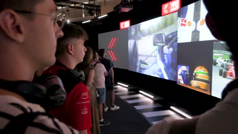 Visitors-watch-exclusive-chronological-footage-illustrating-the-racing-sport's-past-and-present-during-the-world's-first-official-Formula-1-exhibition-at-IFEMA-in-Madrid,-Spain