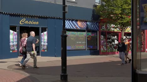 Slow-motion-people-walking-in-British-town-passing-casino-and-shops-during-high-inflation-cost-of-living-crisis