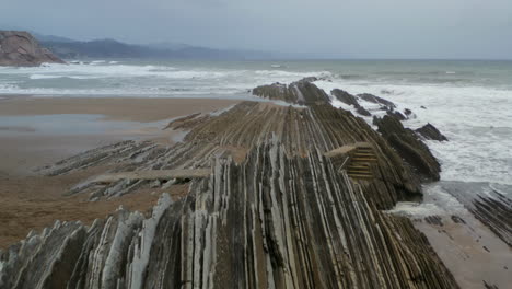 Low-dolly-above-sharp-jagged-rocks-at-itzurun-beach-zumaia-spain
