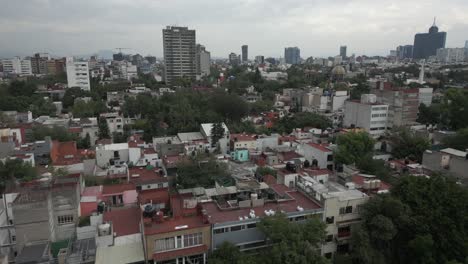 Low-neighborhood-flyover-aerial,-buildings-and-trees-in-Mexico-City