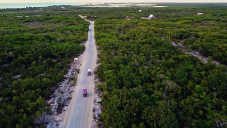 Aerial-following-golfcarts-used-by-tourists-near-the-'Secret-Beach-Belize'-on-Ambergris-Caye-or-Bay,-Belize
