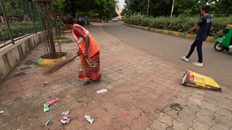 RMC-female-worker-cleaning-garbage-in-early-morning,-worker-cleaning-garbage-on-street-road