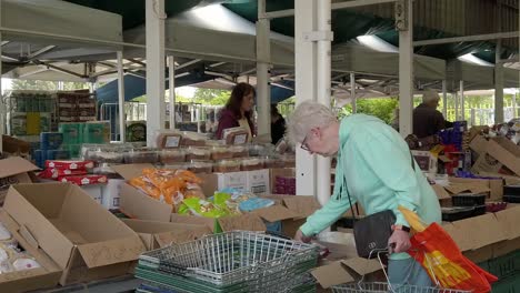 Slow-motion-pensioners-browsing-groceries-in-UK-town-market-stalls-during-cost-of-living-crisis-inflation