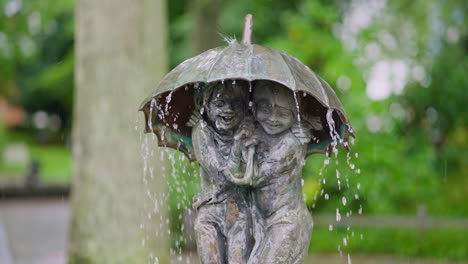 Fountain-with-a-sculpture-of-two-children-under-an-umbrella-by-Sculptor-Frido-Graziani,-Town---Binz,-Germany