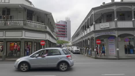 Tráfico-En-El-Centro-De-La-Ciudad-De-Suva,-Fiji,-Con-Un-Fondo-De-Arquitectura-Colonial.