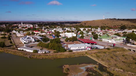 Vista-De-Retroceso-De-Drones-Desde-Beaufort-West-Y-Su-Presa-Inusualmente-Llena-En-Great-Karoo