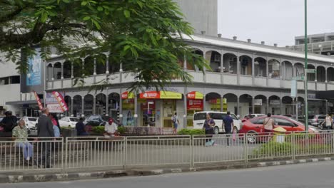 Tráfico-En-El-Centro-De-La-Ciudad-De-Suva,-Fiji,-Con-Edificios-Históricos-De-La-época-Colonial-Al-Fondo.