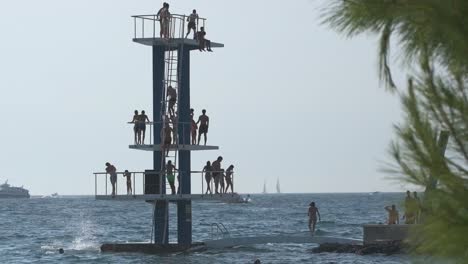 Alejar-La-Plataforma-De-Buceo-De-Tres-Niveles-Con-Personas-Saltando-Al-Mar-En-Zadar,-Croacia