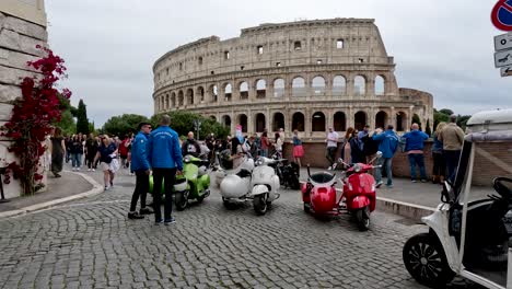 Geparkte-Vespas-Mit-Beiwagen-Auf-Der-Via-Del-Colosseo-25-Mit-Dem-Kolosseum-Im-Hintergrund-In-Rom