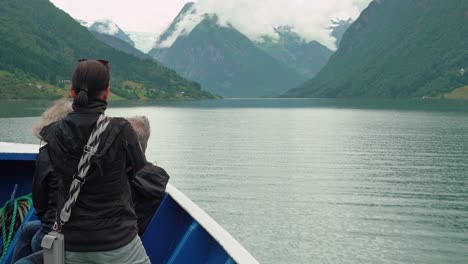 Tourists-watching-Boyabreen-glacier-far-away-in-mountains-while-traveling-the-Fjaerlandsfjord-in-a-boat---Norway