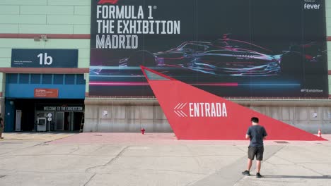A-visitor-stands-at-the-entrance-of-the-world's-first-official-Formula-1-exhibition-at-IFEMA-in-Madrid,-Spain