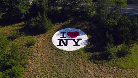 Una-Vista-Aérea-De-Un-Logotipo-De-I-Love-New-York-En-El-Césped-Entre-Las-Autopistas-De-Long-Island,-Nueva-York,-En-Un-Día-Soleado