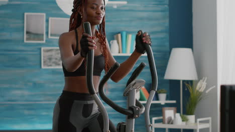 Fit-slim-woman-trainer-wearing-sportswear-training-body-muscles-working-on-elliptical-bike